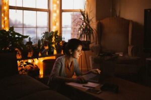 Woman using a voice assistant beside a lamp, showing best smart home starter kits for beginners in action.